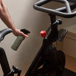 Guests on Earth All-Purpose Cleaner spritzed on an exercise bike, wiping handlebars for a fresh, streak-free clean