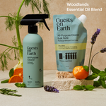 Guests on Earth all-purpose cleaner and refill pouch, styled with citrus, herbs, and florals in a warm product scene.