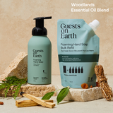 Guests on Earth foaming hand soap and bulk refill, styled in a warm Woodlands essential oil blend product display.