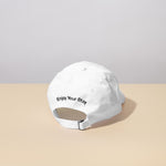 Guests on Earth Ambassador Cap back view: white adjustable strap with Enjoy Your Stay embroidery