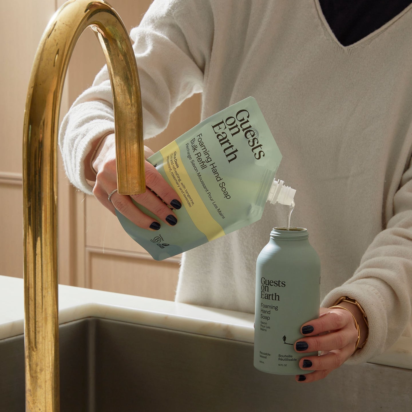 Guests on Earth Foaming Hand Soap Bulk Refill pouch poured into reusable bottle at the kitchen sink