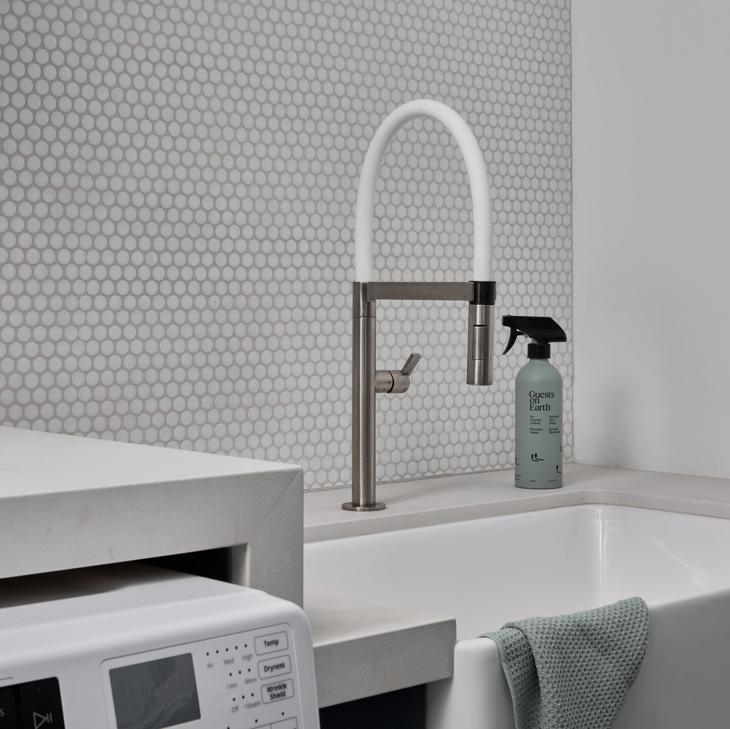 Guests on Earth All-Purpose Cleaner beside a utility sink and washer in a bright laundry room, ready for quick wipe-downs