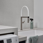 Guests on Earth All-Purpose Cleaner beside a utility sink and washer in a bright laundry room, ready for quick wipe-downs