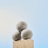 Guests on Earth is a producer of non-toxic cleaning products: wool dryer balls stacked on a stone block
